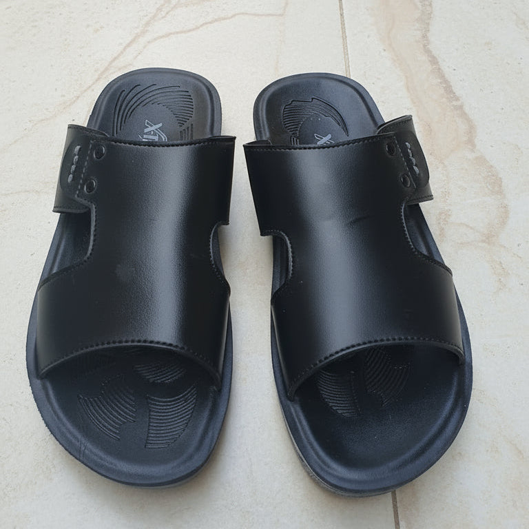 Black sandals on a light-colored tiled floor