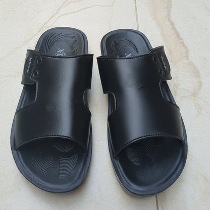 Black sandals on a light-colored tiled floor